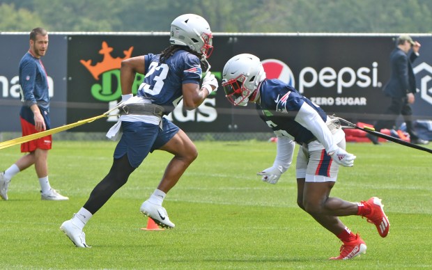 Kyle Dugger and a team mate run while dragging weight during Patriots practice. Staff Photo Chris Christo/Boston Herald